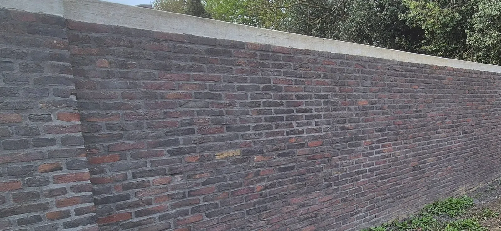 Detail van gemêleerd rood metselwerk van een tuinmuur